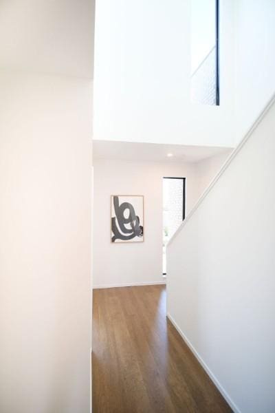 hallway featuring dark hardwood / wood-style floors and a towering ceiling