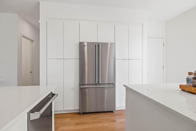 kitchen featuring white cabinets, light hardwood / wood-style floors, and high quality fridge