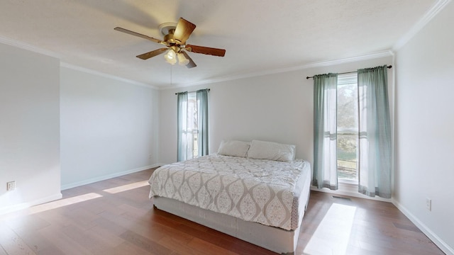 bedroom featuring hardwood / wood-style floors, ceiling fan, crown molding, and multiple windows