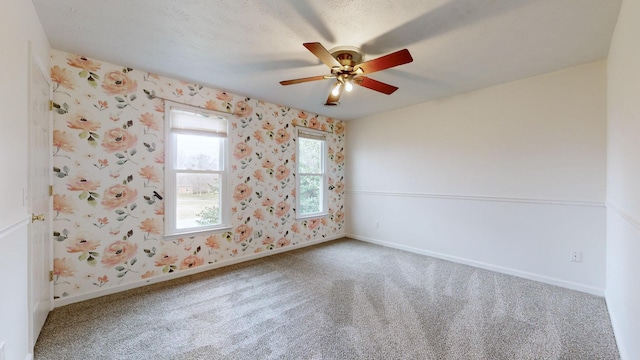 carpeted spare room featuring ceiling fan