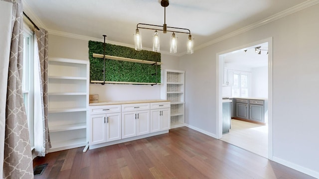 kitchen with light wood-type flooring, decorative light fixtures, white cabinetry, and crown molding