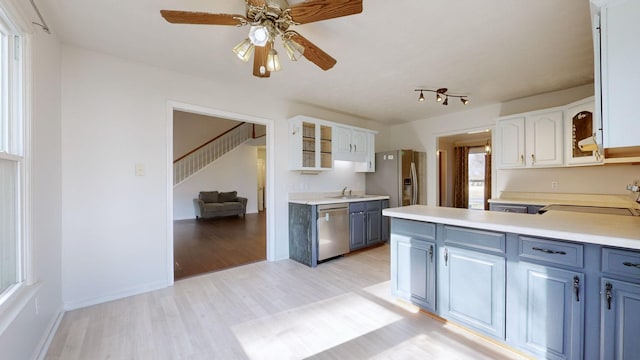 kitchen featuring white cabinetry, ceiling fan, stainless steel appliances, and light wood-type flooring