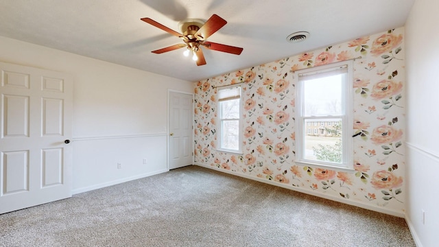 carpeted spare room with ceiling fan