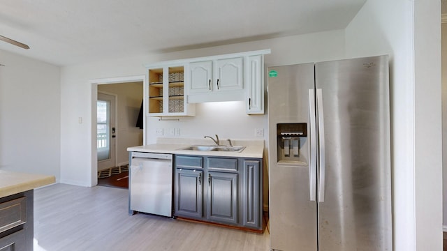 kitchen featuring stainless steel refrigerator with ice dispenser, light wood-type flooring, dishwashing machine, sink, and white cabinets