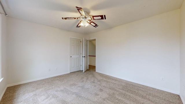 carpeted spare room featuring ceiling fan