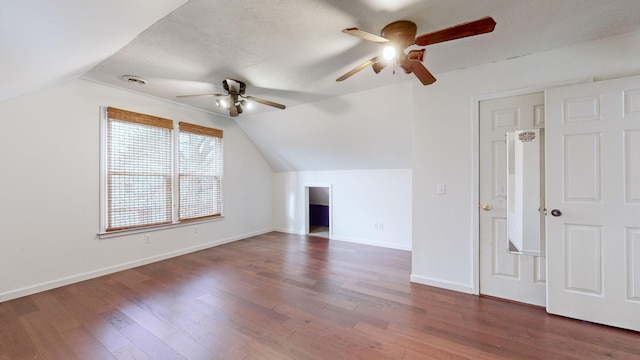 bonus room with ceiling fan, dark hardwood / wood-style floors, a textured ceiling, and vaulted ceiling