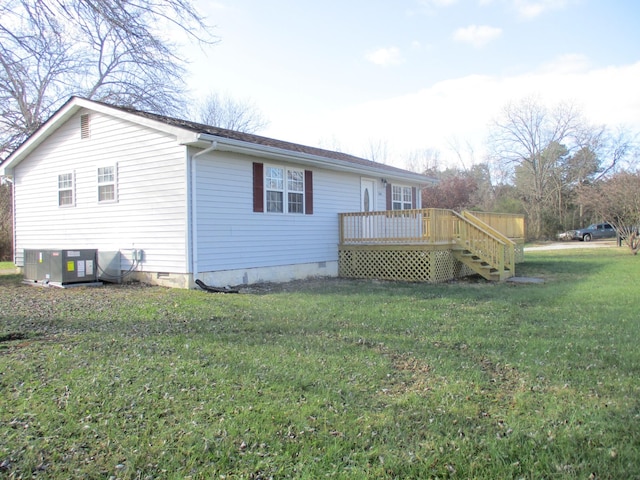 view of side of home featuring central AC unit, a deck, and a yard