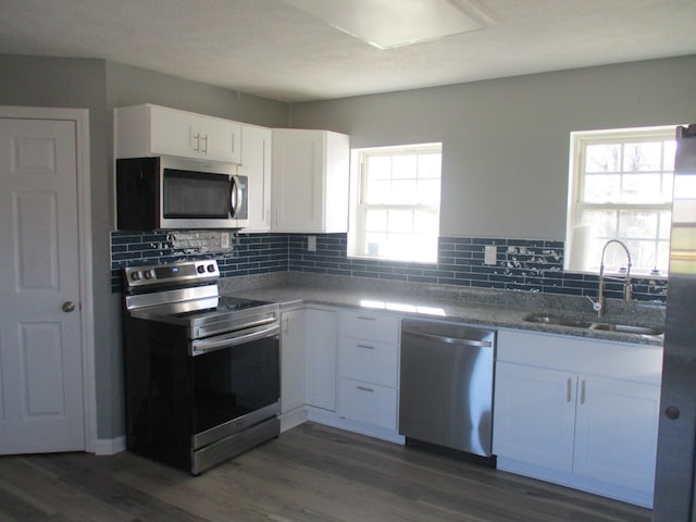 kitchen with white cabinets, stainless steel appliances, dark wood-type flooring, and sink