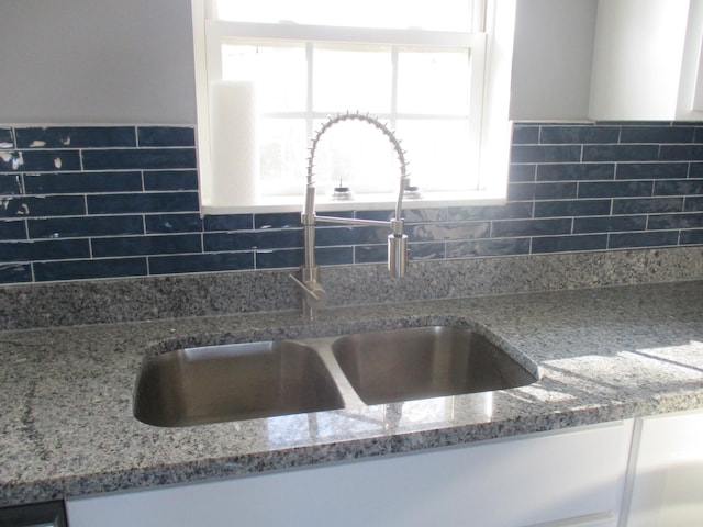 kitchen featuring light stone countertops and sink