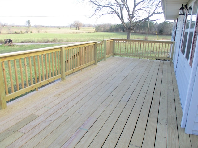 wooden deck featuring a lawn and a rural view