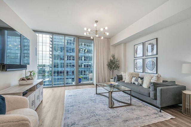 living room featuring light wood-type flooring, an inviting chandelier, and a wall of windows