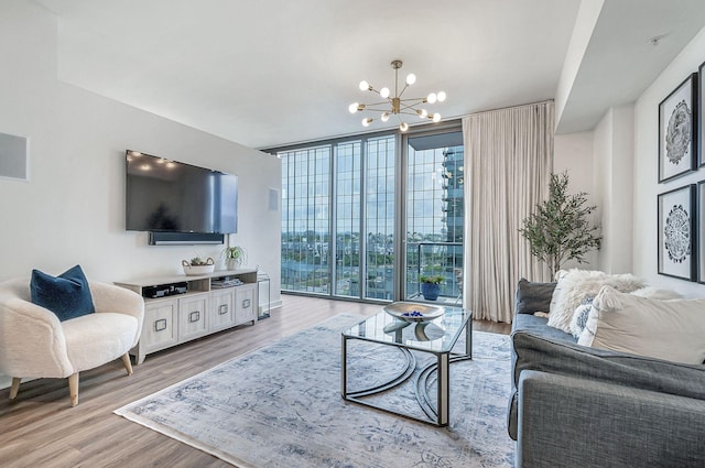 living room with light hardwood / wood-style flooring, an inviting chandelier, and expansive windows