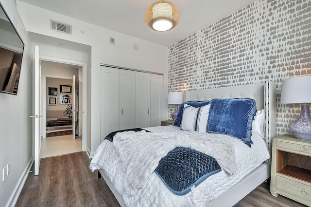 bedroom with a closet and dark hardwood / wood-style flooring