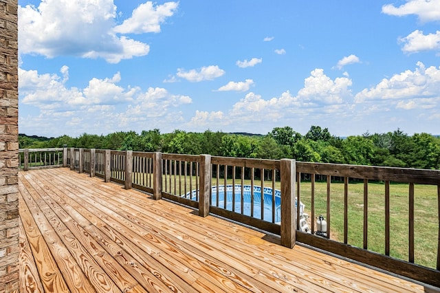 wooden terrace featuring a lawn and a pool