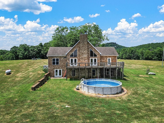 rear view of property with french doors, a yard, and a wooden deck