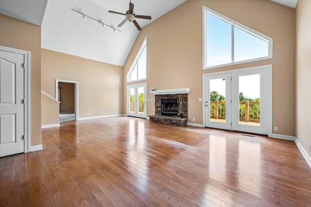 unfurnished living room with ceiling fan, light wood-type flooring, and rail lighting