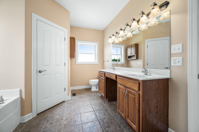 bathroom featuring vanity, a bathtub, and toilet