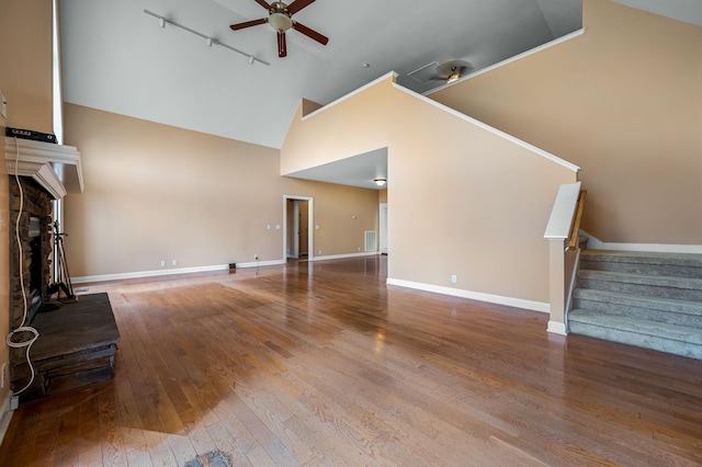 unfurnished living room featuring ceiling fan, rail lighting, high vaulted ceiling, and hardwood / wood-style flooring