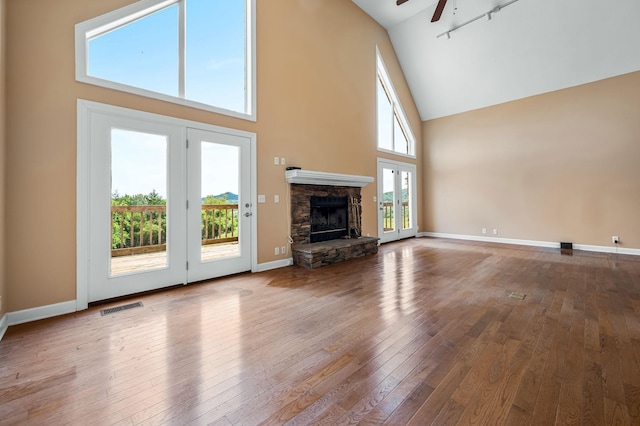 unfurnished living room with ceiling fan, a healthy amount of sunlight, and a fireplace