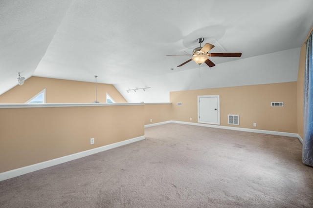 spare room featuring carpet, ceiling fan, and lofted ceiling