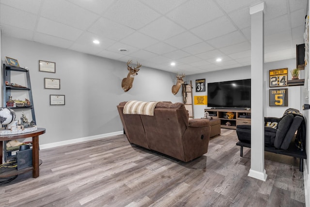 living room with a paneled ceiling and hardwood / wood-style flooring