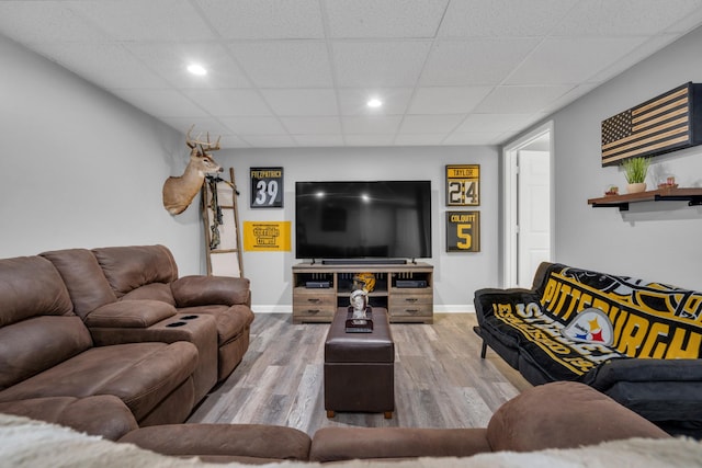 living room with wood-type flooring and a drop ceiling