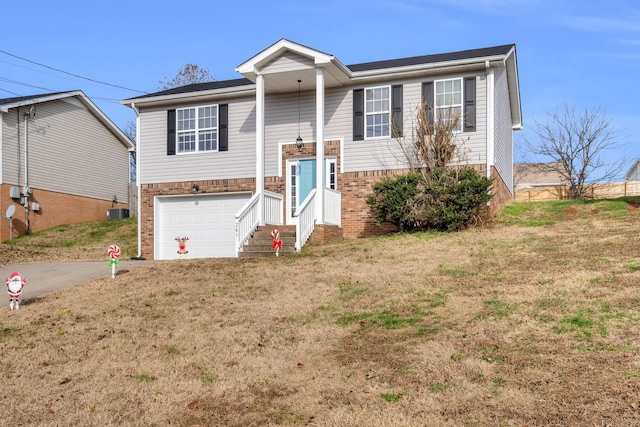 split foyer home with a garage, central air condition unit, and a front lawn