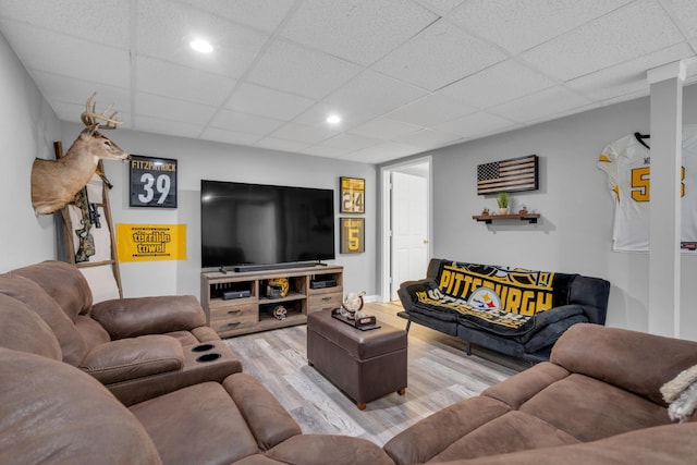 living room with a paneled ceiling and light hardwood / wood-style floors