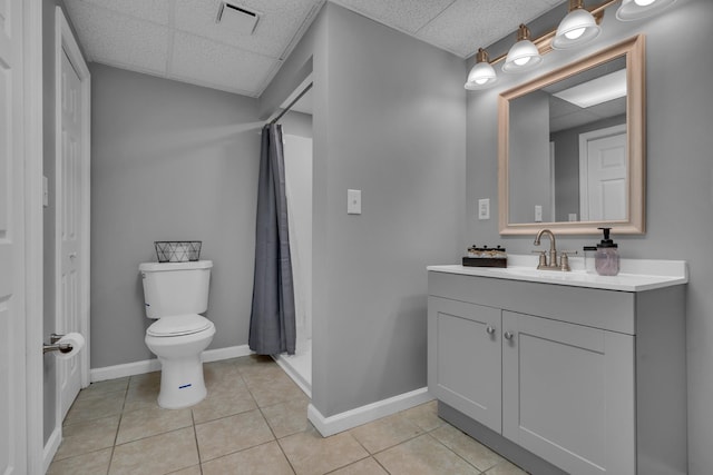 bathroom featuring a paneled ceiling, vanity, a shower with curtain, tile patterned flooring, and toilet