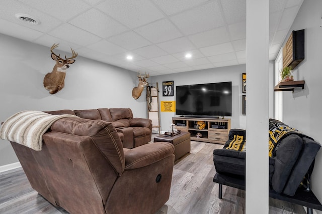 living room featuring hardwood / wood-style floors and a paneled ceiling