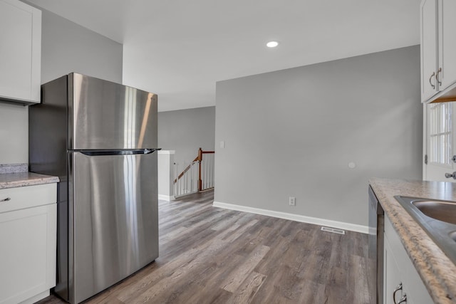 kitchen featuring white cabinets, stainless steel appliances, and light hardwood / wood-style flooring