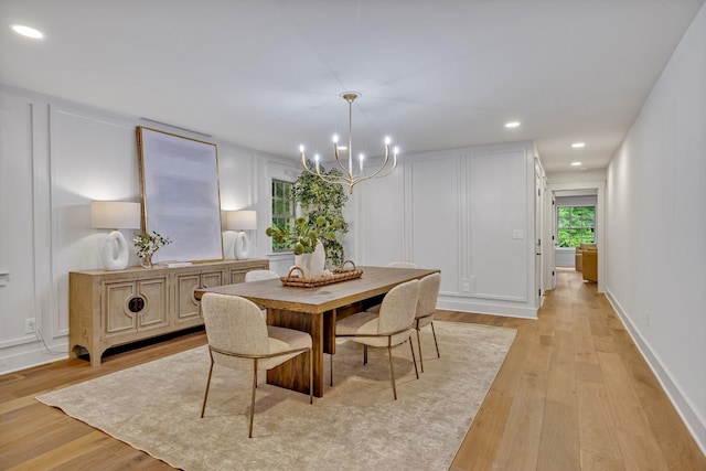 dining room with an inviting chandelier and light hardwood / wood-style flooring