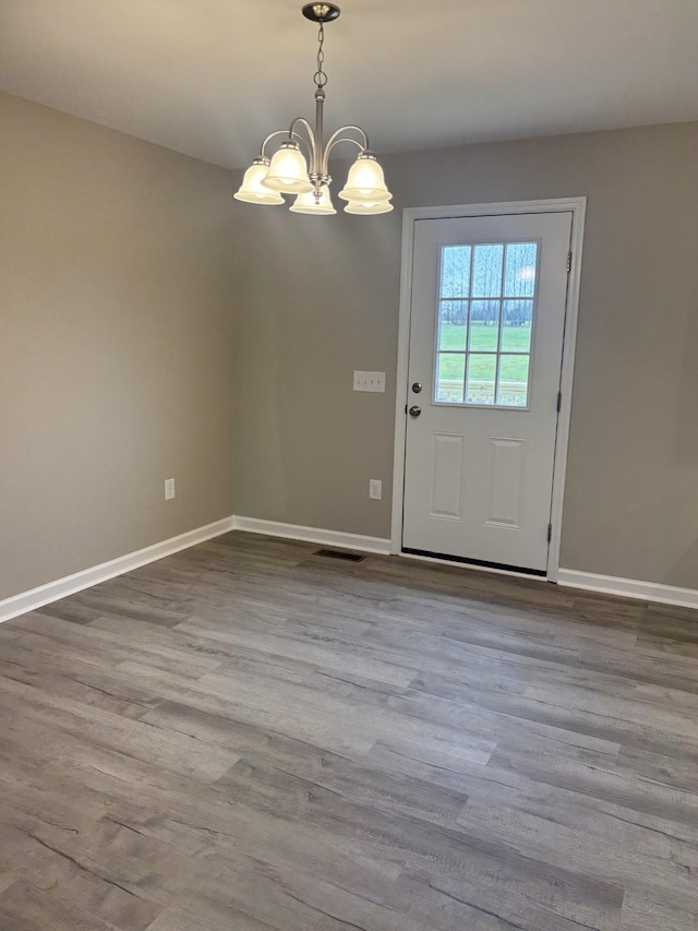 doorway to outside featuring a chandelier and light wood-type flooring