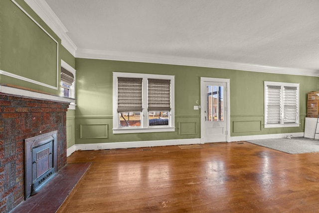 unfurnished living room featuring hardwood / wood-style flooring and ornamental molding