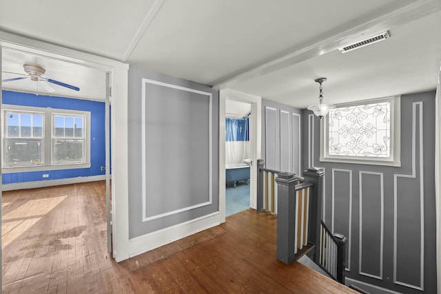 corridor with dark wood-type flooring and an inviting chandelier