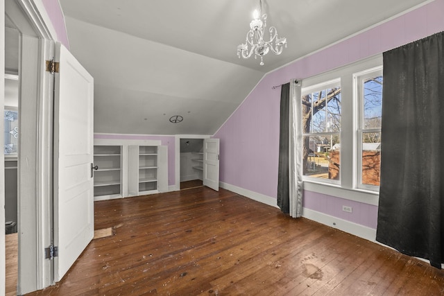 additional living space featuring built in shelves, dark hardwood / wood-style flooring, a chandelier, and vaulted ceiling