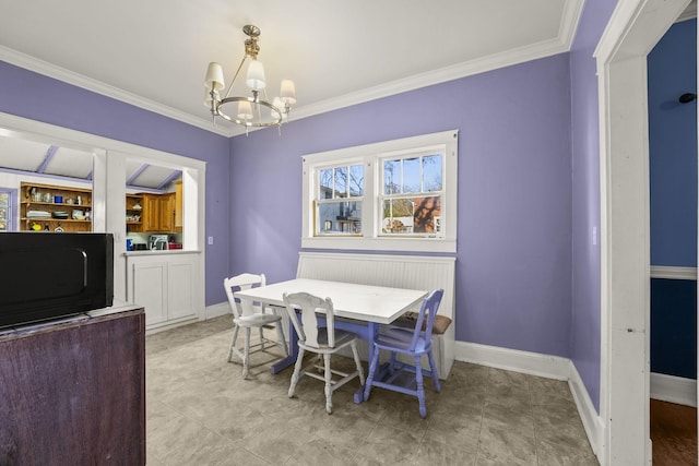 dining room with ornamental molding and an inviting chandelier