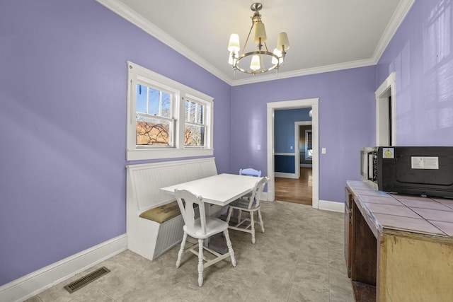 dining area featuring ornamental molding and an inviting chandelier