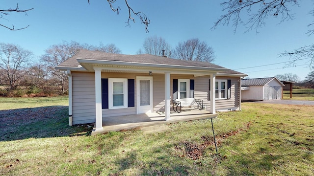 back of property featuring covered porch and a lawn