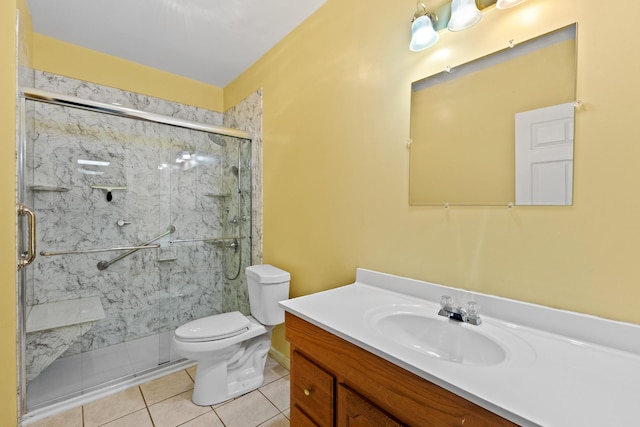 bathroom with tile patterned flooring, vanity, a shower with shower door, and toilet