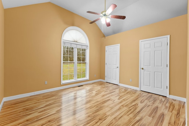 unfurnished bedroom with ceiling fan, light hardwood / wood-style floors, high vaulted ceiling, and multiple windows