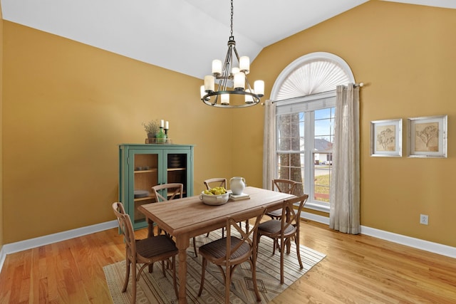 dining room featuring a chandelier, light hardwood / wood-style flooring, and lofted ceiling