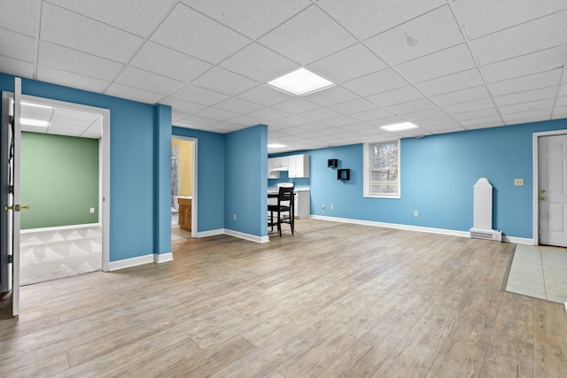 basement with a paneled ceiling and hardwood / wood-style floors