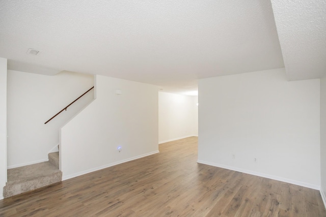 basement with a textured ceiling and hardwood / wood-style flooring