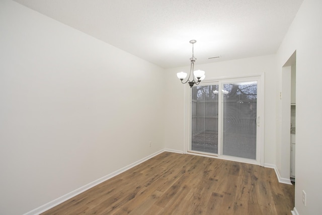 unfurnished dining area with dark hardwood / wood-style floors and a chandelier