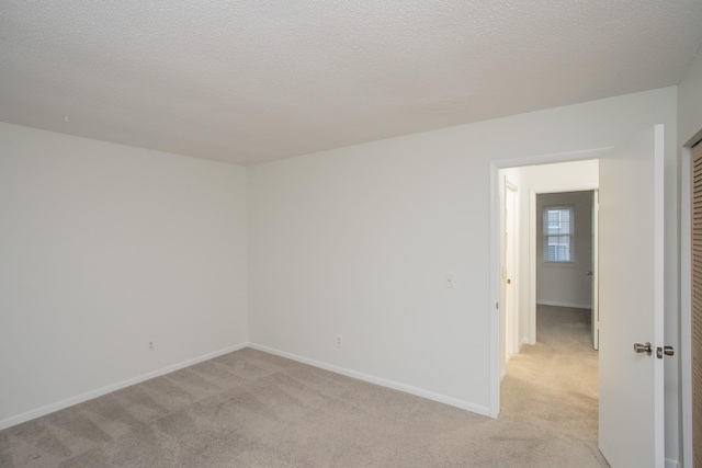 carpeted spare room with a textured ceiling