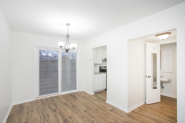 unfurnished dining area with light hardwood / wood-style flooring and an inviting chandelier