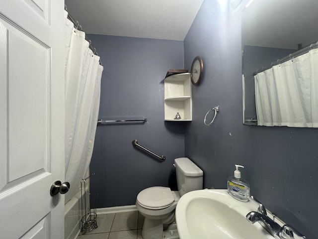 bathroom featuring toilet, tile patterned floors, and sink