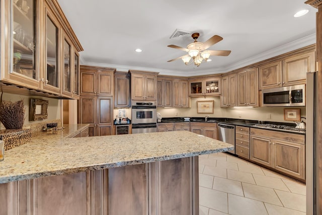 kitchen with kitchen peninsula, light stone countertops, ornamental molding, and appliances with stainless steel finishes