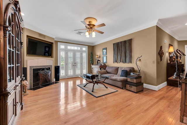 living room with crown molding, a fireplace, and light wood-type flooring